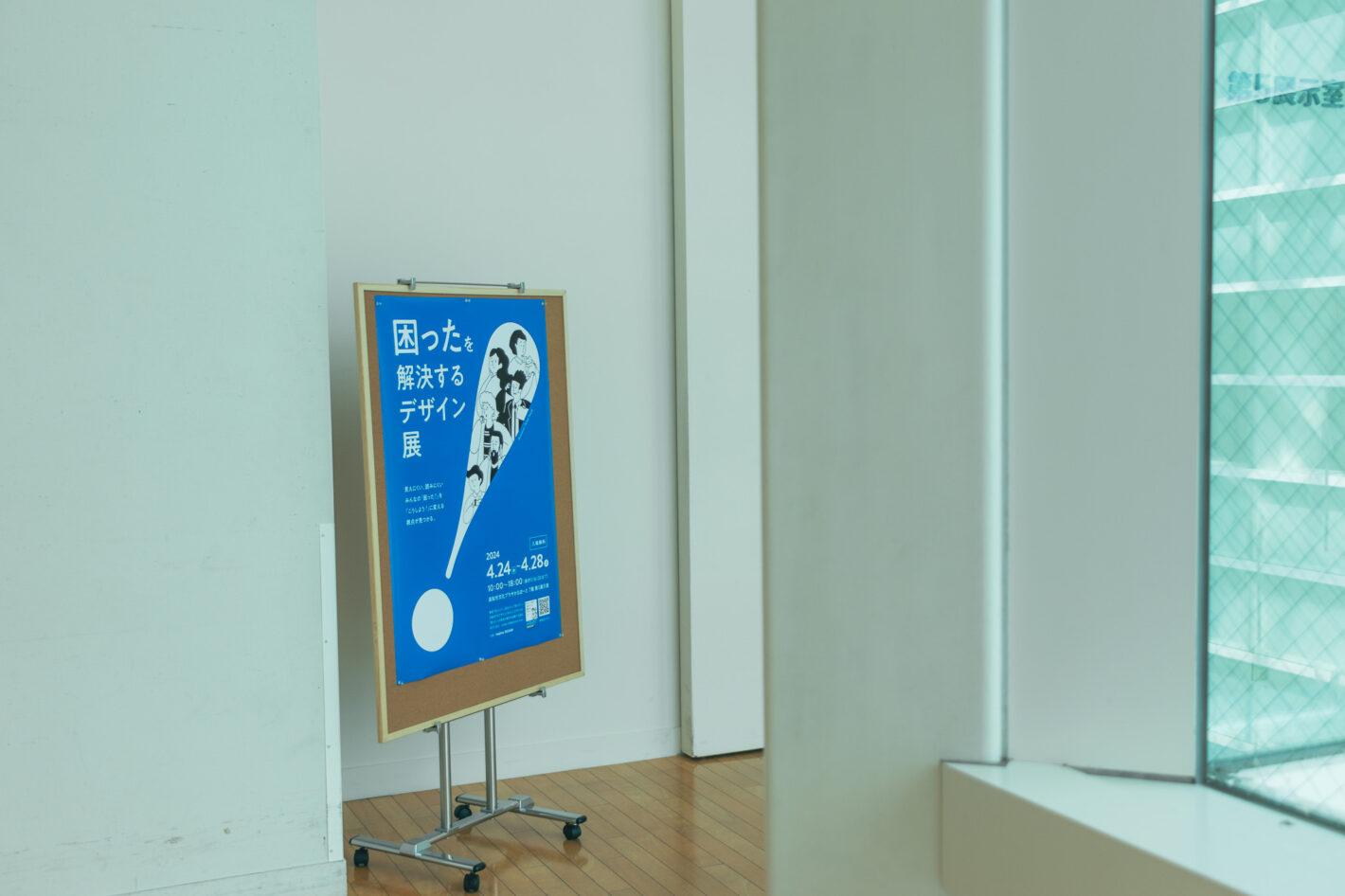 写真：展のポスターを貼ったスタンドが廊下に立っている
