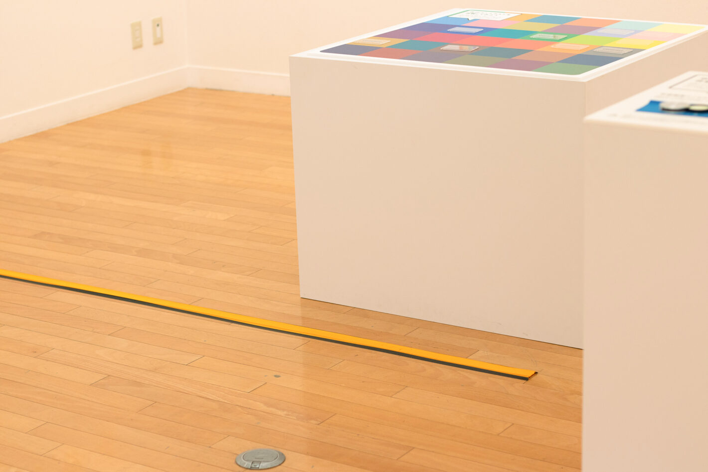 写真：床に5センチ幅くらいの黄色いテープが敷いてあります。